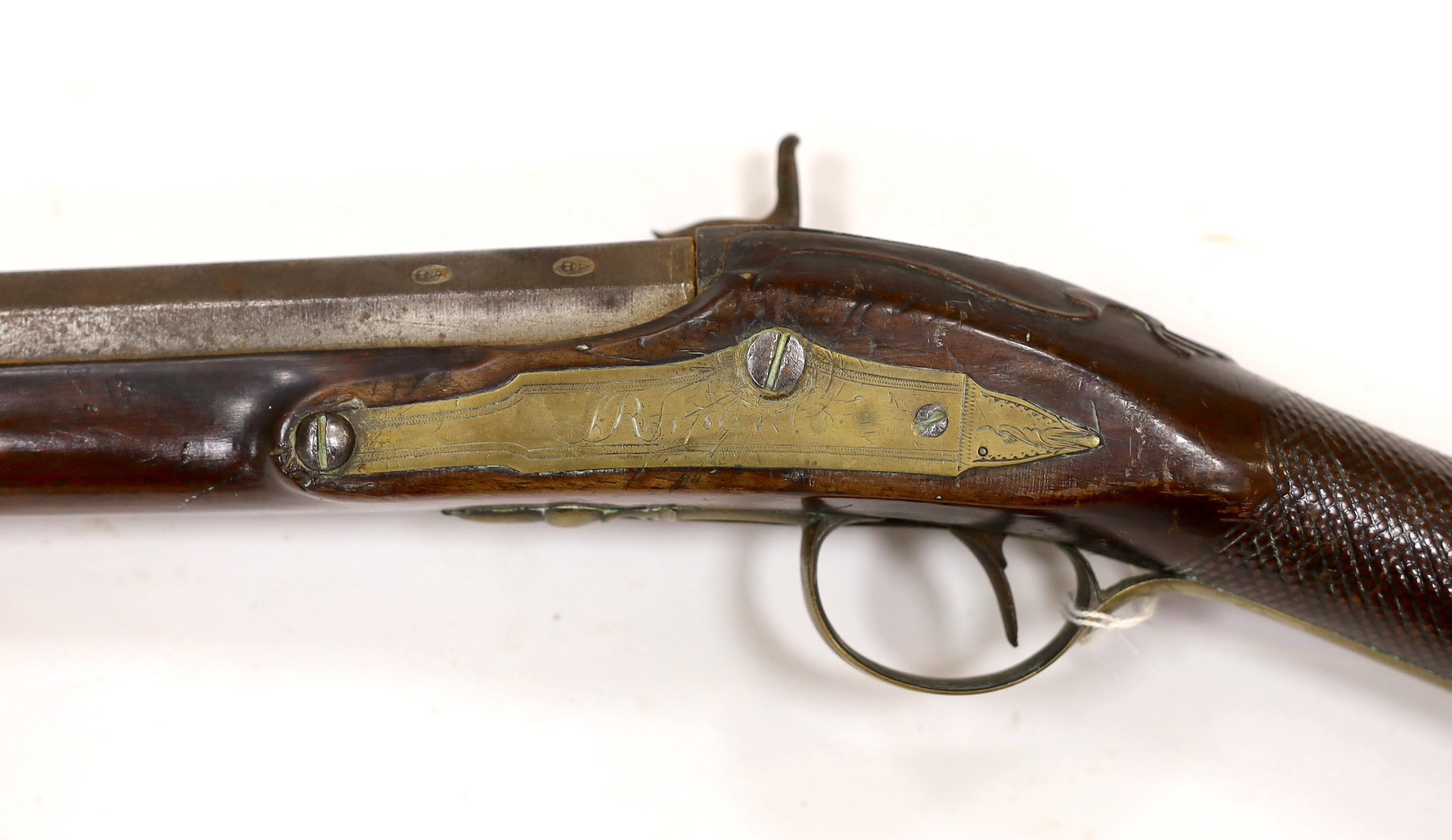 A 1786 percussion 12 bore fowling piece, converted from flintlock, with a fully stocked half octagonal barrel, London proofs, brass furniture and sideplate engraved IR 1786, chequered grip and wooden ramrod, barrel 96cm